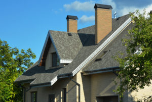 A house with a pitched roofing construction with asphalt shingles and attic windows